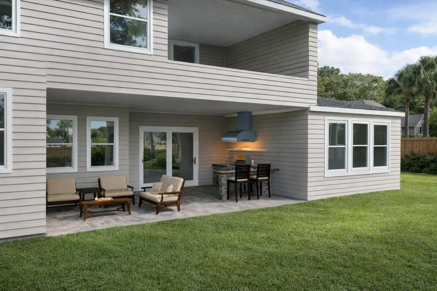 3D rendering: covered patio with dining and lounge areas on a two-story home